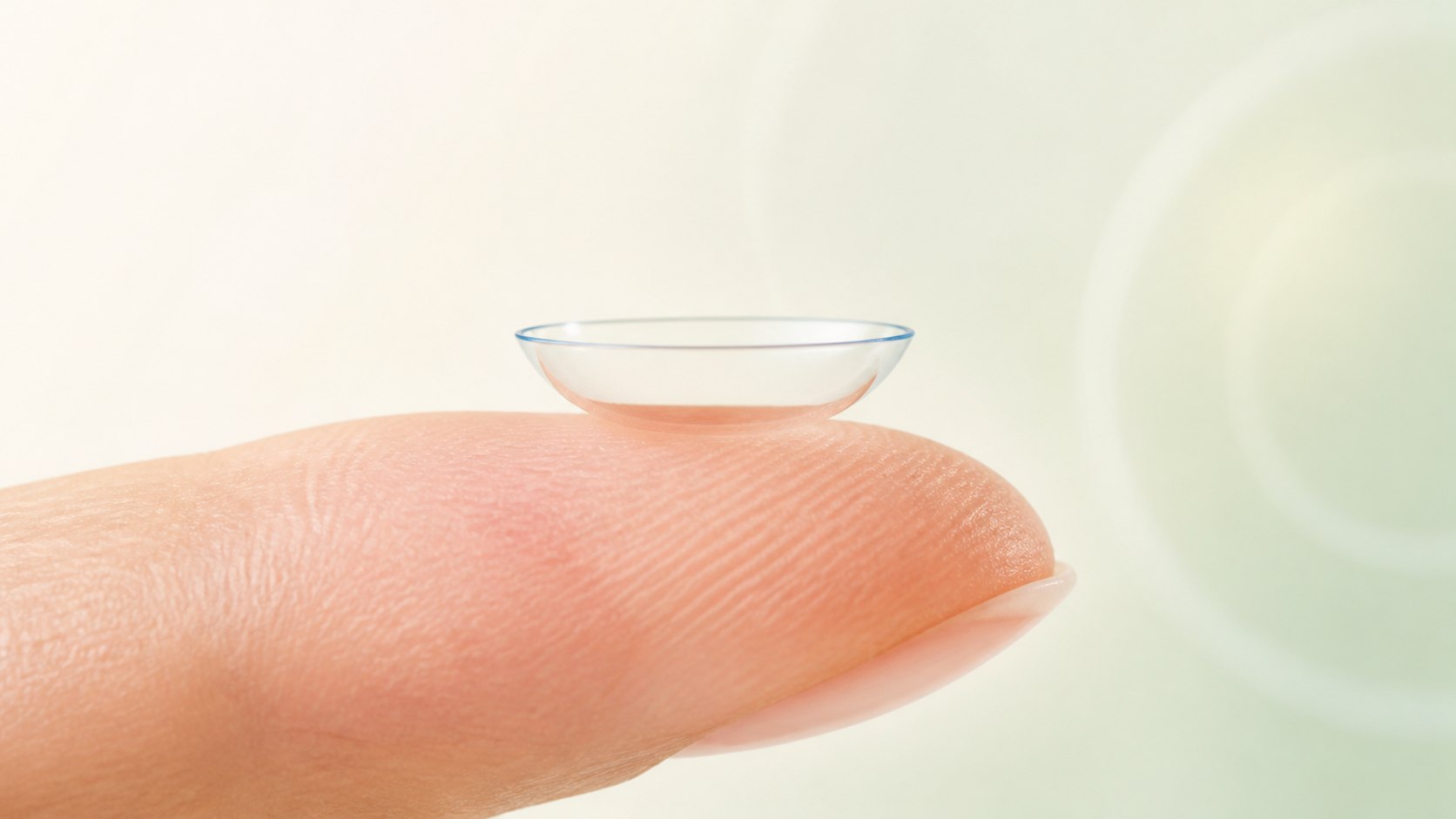 Correctly oriented contact lens forming a smooth bowl shape on a fingertip